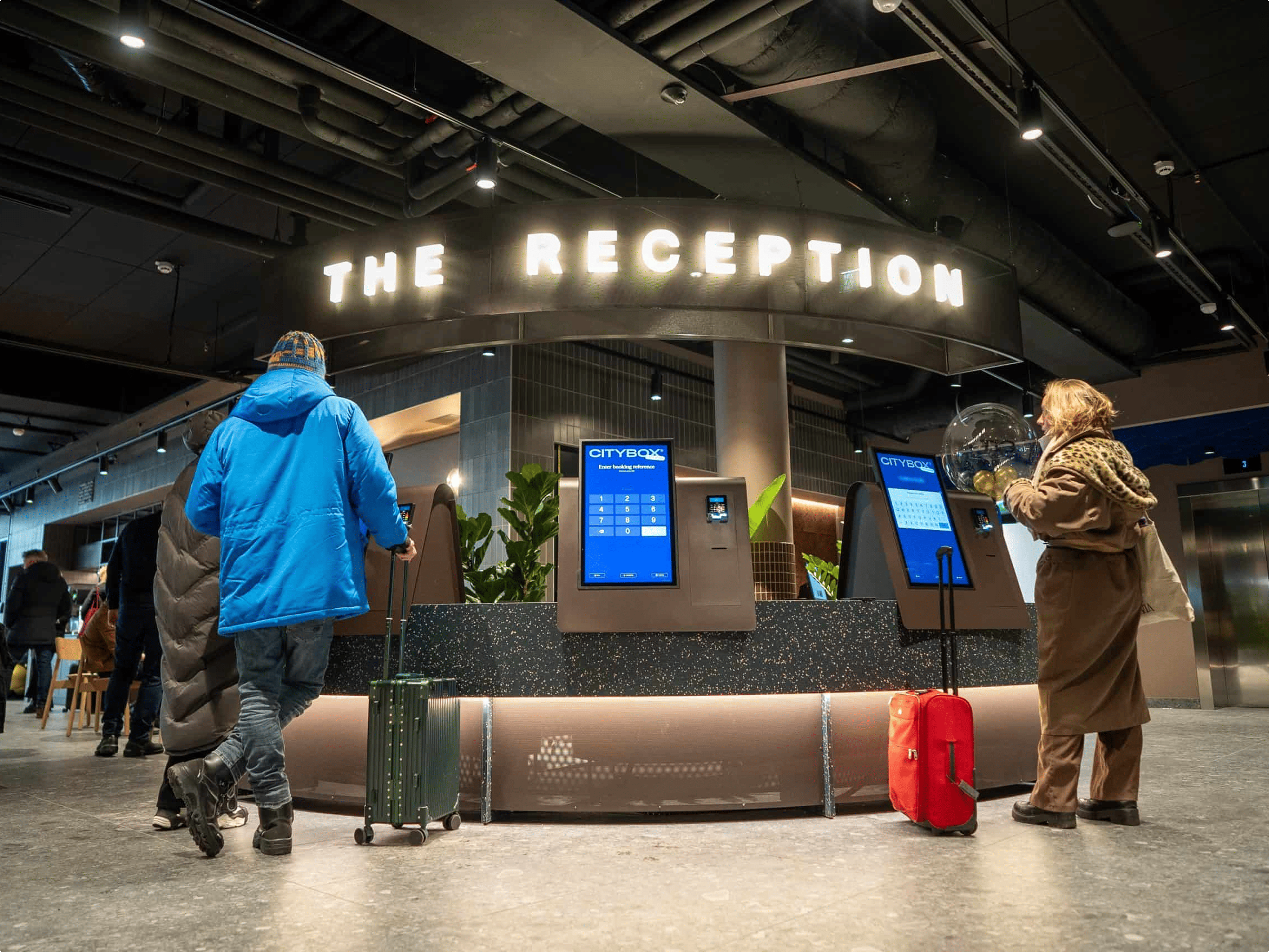 Wide reception with multiple Citybox self-service kiosks and guests using them. Credit: Markus Gjengaar, Citybox.